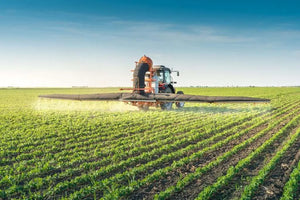 Tractor spraying pesticides on soy bean