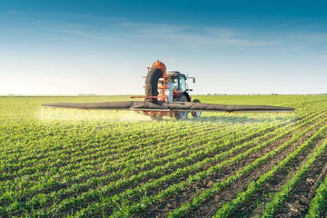 Tractor spraying pesticides on soy bean